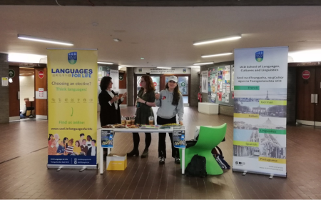 Staff and students at table with banners next and right